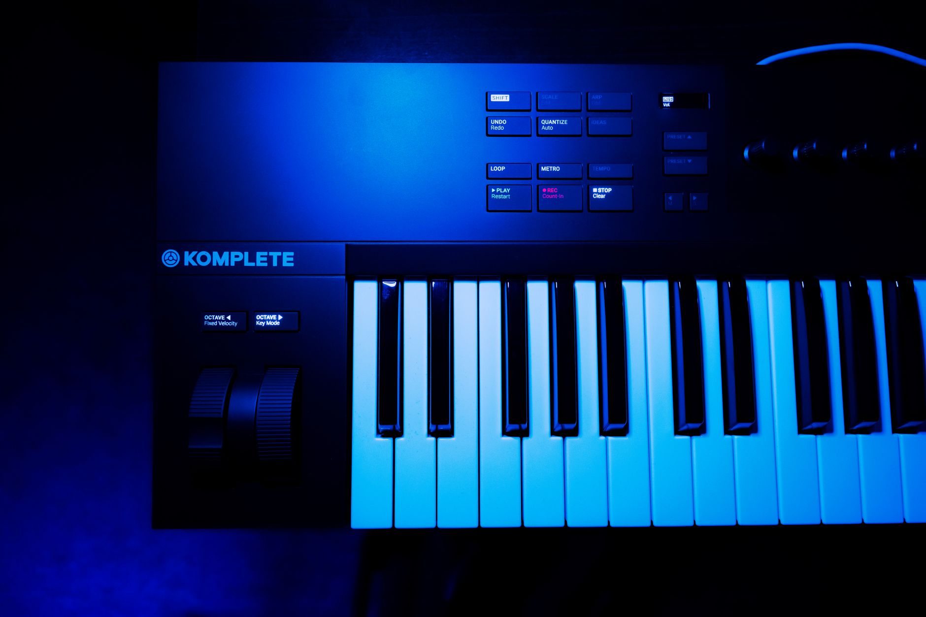 A close-up view of a synthesizer keyboard under blue lighting, perfect for music production or electronic media.