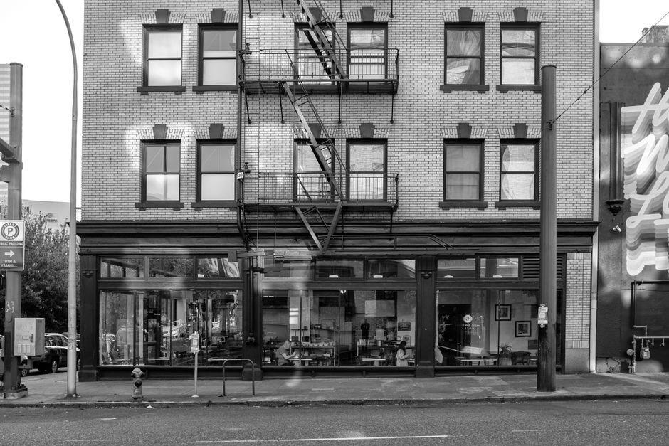 Charming urban cafe with classic facade in black and white street scene.