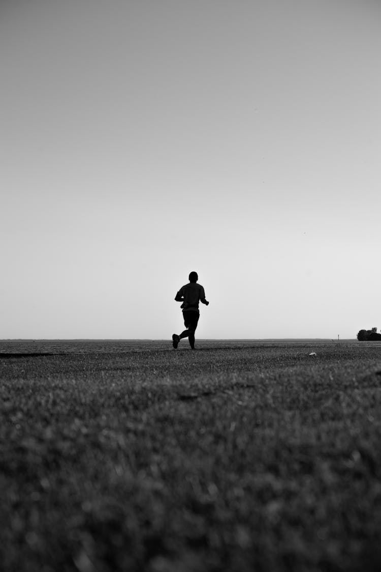 Silhouette Of A Person Running On The Field