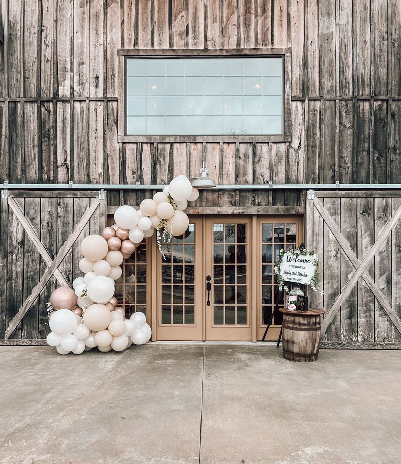 Rustic decorated entrance with balloons and wooden accents