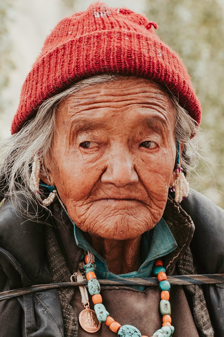 Close-Up Photo Of An Old Woman Wearing Red Knit Cap