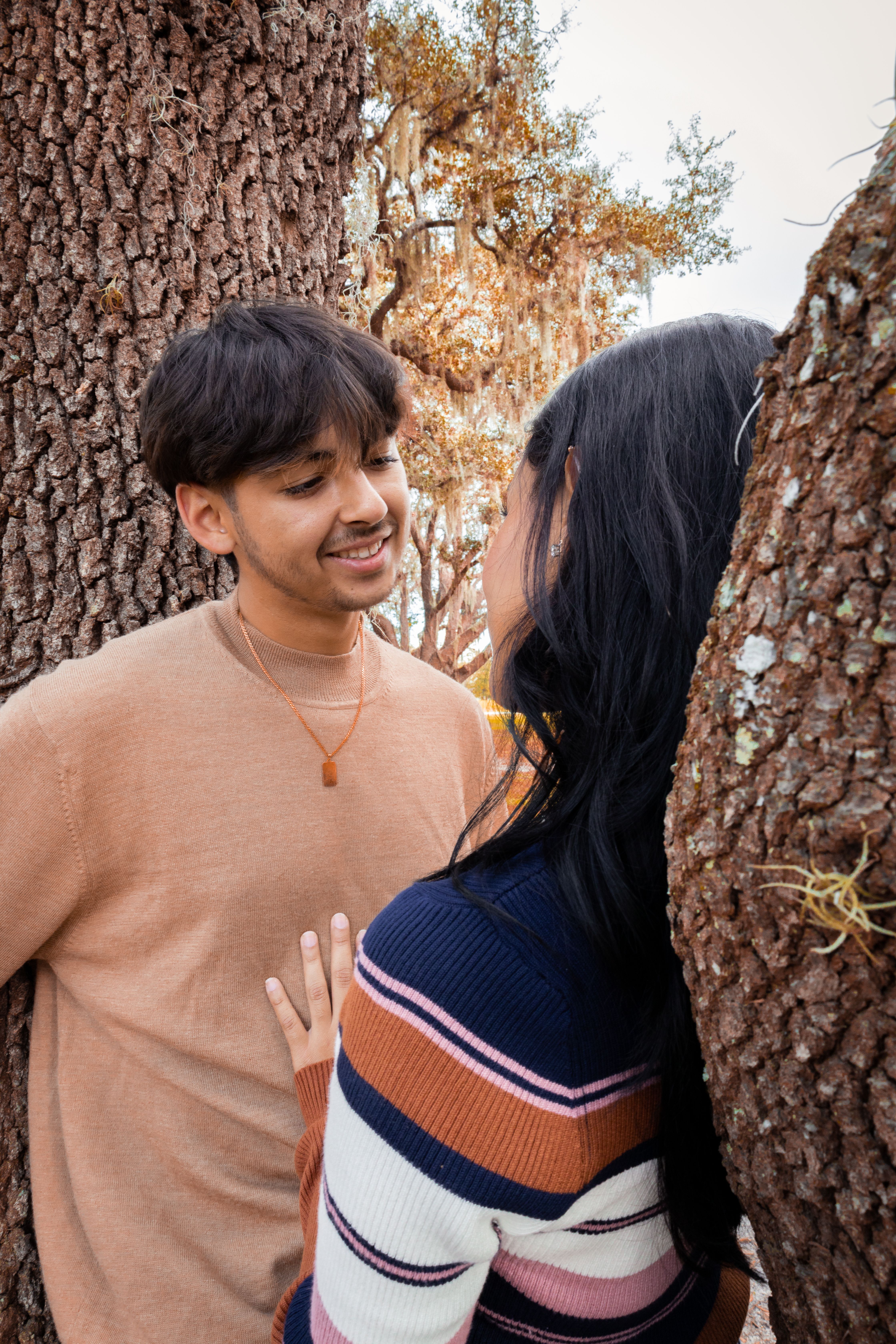 Man and Woman Standing beside Brown Tree Trunks · Free Stock Photo
