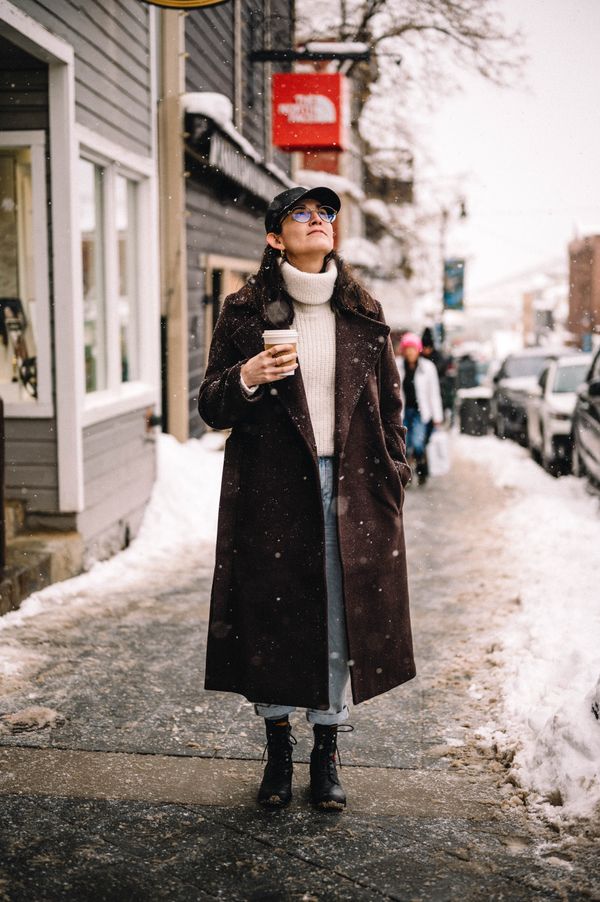 Woman in jeans with turtleneck and long coat