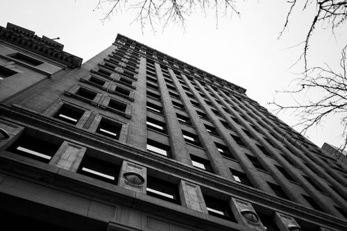 Free Low-angle view of an urban high-rise building facade in black and white. Stock Photo