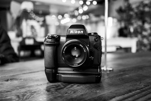 Close-up of a Nikon F100 Camera Standing on a Wooden Table · Free Close-up of a Nikon F100 Camera Standing on a Wooden Table · Free
