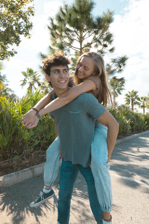 Handsome young man hugging his girl friend from back, holding her