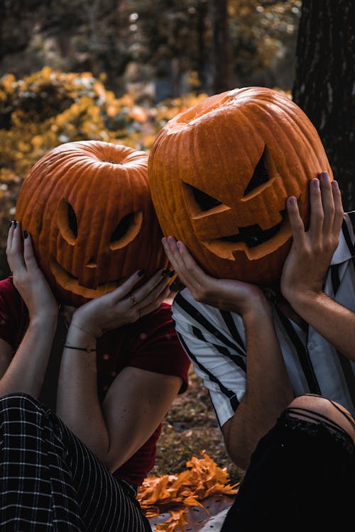 Two People Wearing Jack-O-Lantern on Their Heads