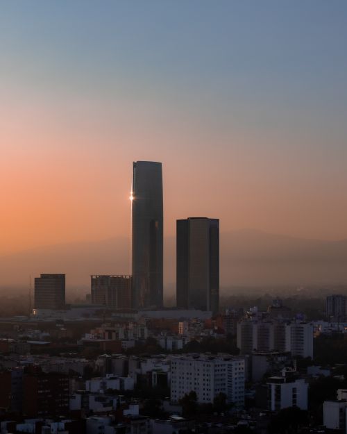 Free Dramatic sunrise illuminating skyscrapers in Mexico City's skyline, showcasing its urban architecture. Stock Photo