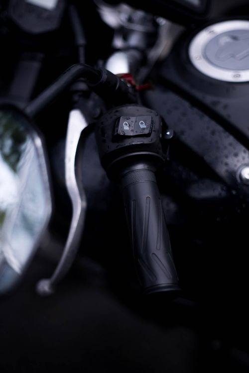 Free Detailed shot of a motorcycle handlebar with raindrops, highlighting controls and grip. Stock Photo
