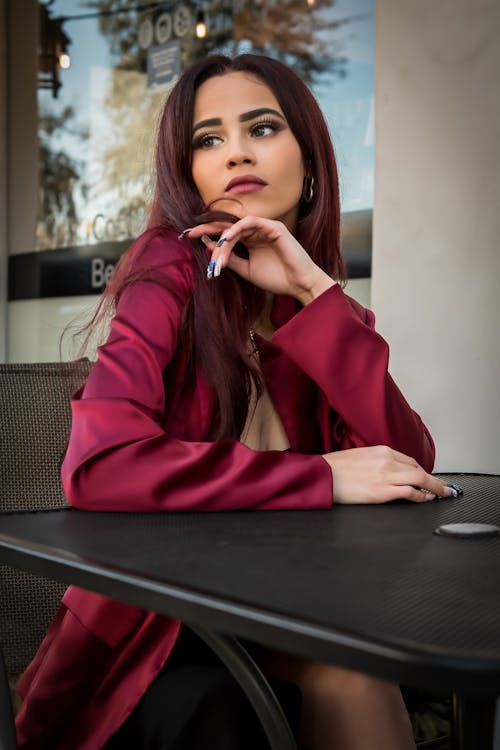 Woman in Red Coat Sitting by Table