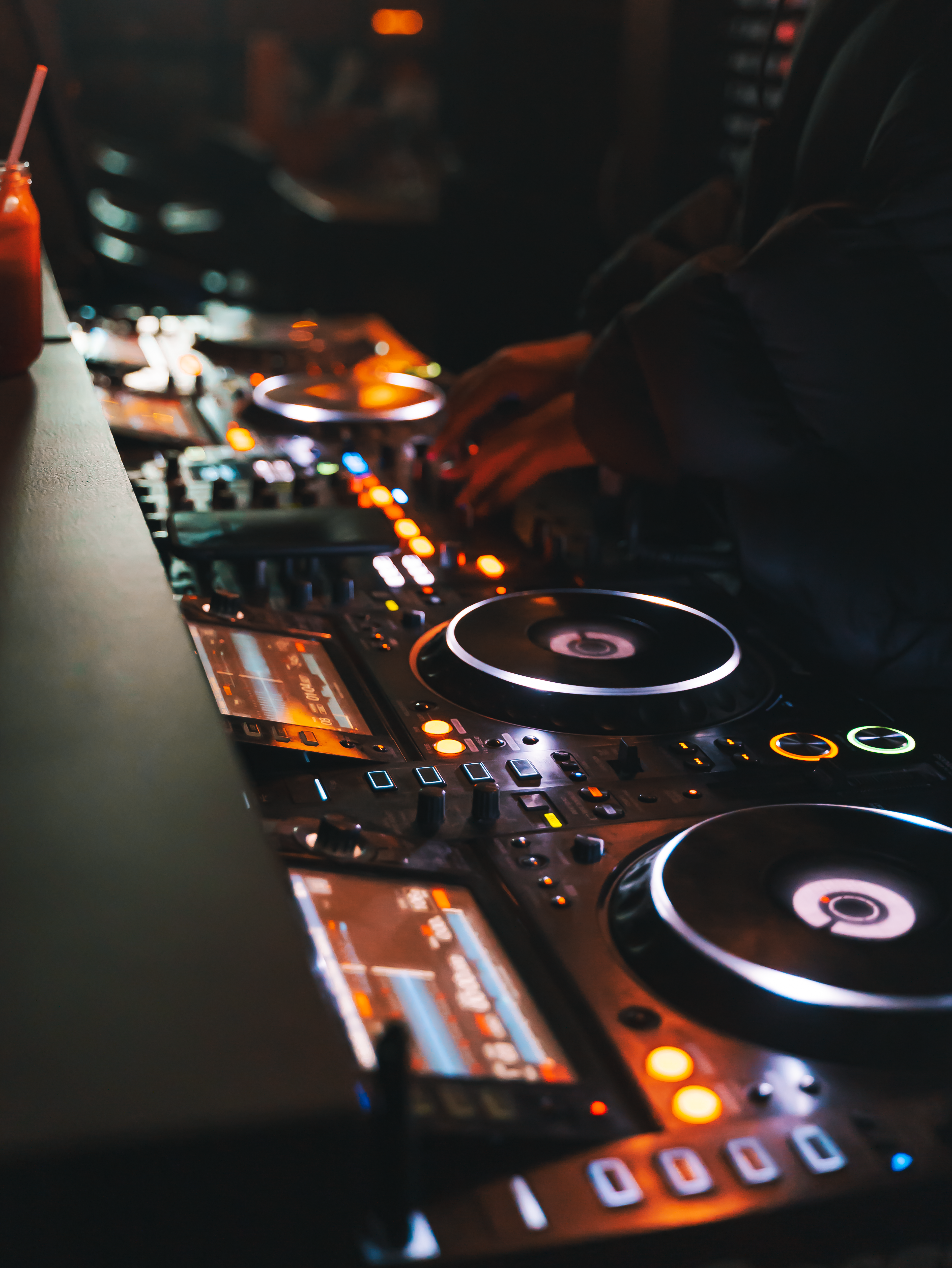 DJ skillfully mixes tracks with a sound mixer in a vibrant nightclub setting.