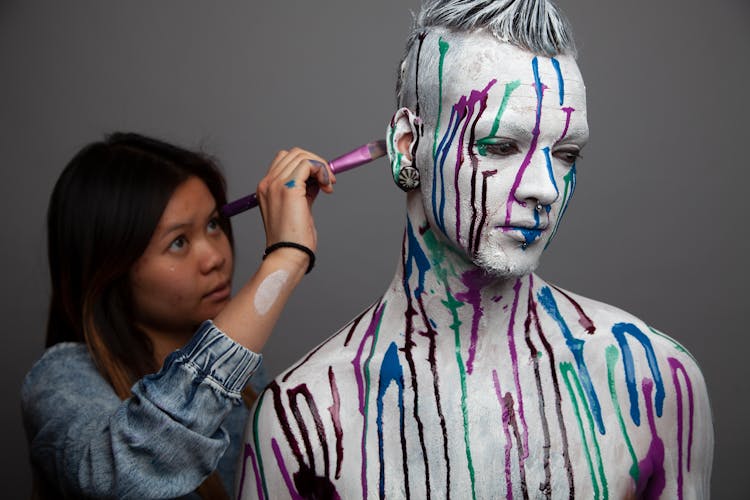 A Man Painting On Man's Head