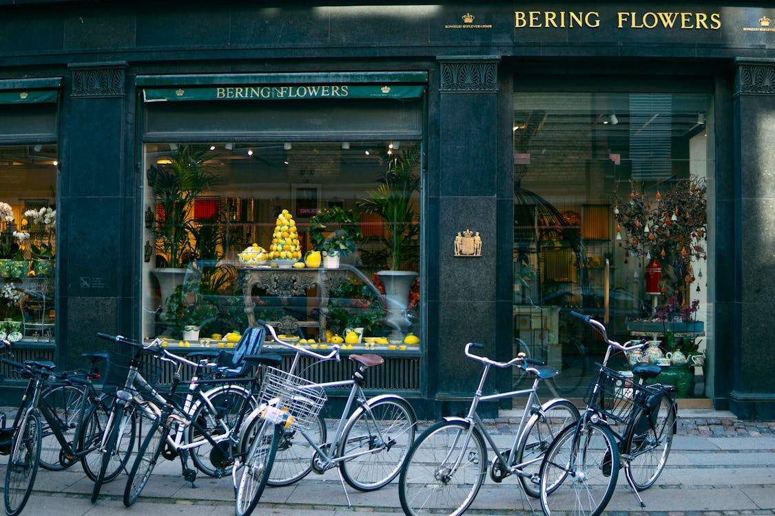 Several Assorted-color Bikes Parked in Front of Bering Flowers Facade