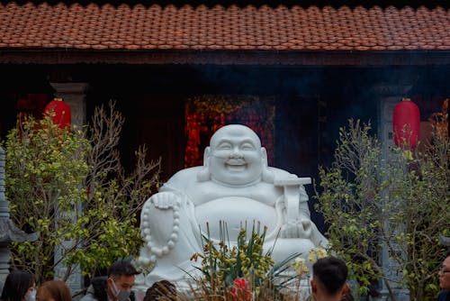 Buddha Sculpture among Trees near Temple