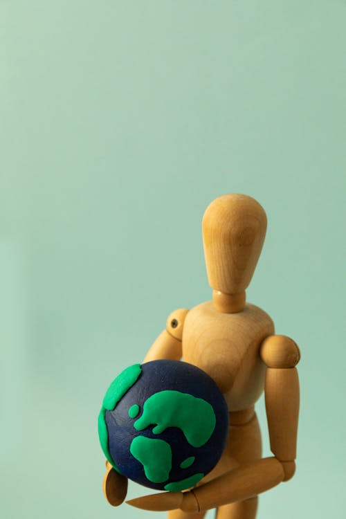Wooden Figure Holding a Plasticine Earth