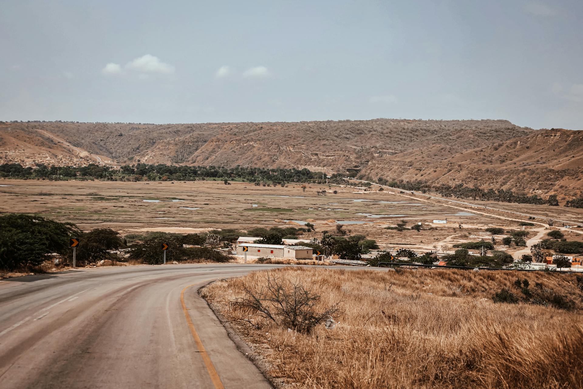 Explore the arid landscapes of Angola featuring winding roads and hill views.