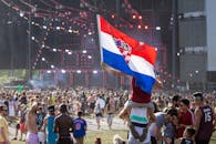 节日人群充满活力，享受着热闹的户外活动，克罗地亚国旗在其中格外显眼