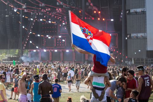 Free Vibrant festival crowd enjoying a lively outdoor event with a Croatian flag displayed prominently. Stock Photo