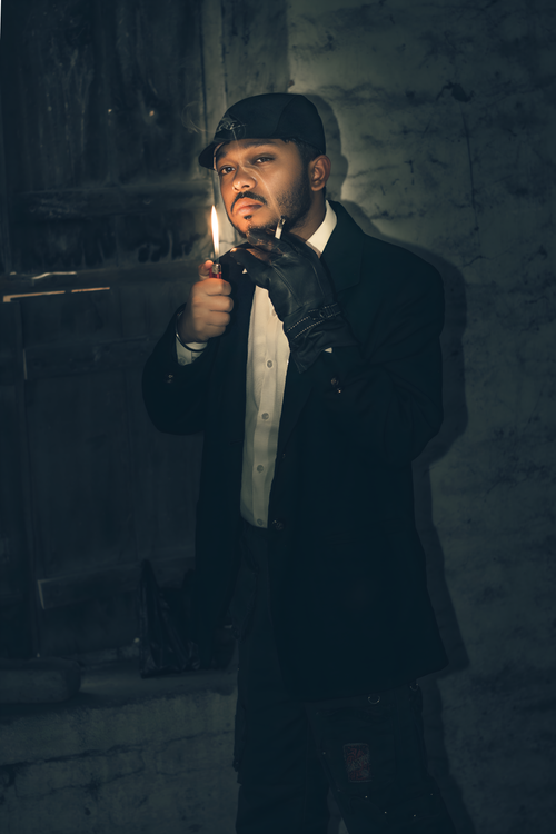 Free A man in gloves lights a cigarette with a lighter in a dimly lit alley at night. Stock Photo