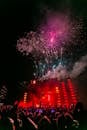 晚上，充满活力的户外音乐会上，人群欣赏着现场音乐和烟火表演