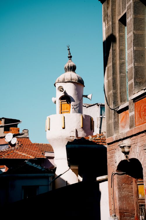 Free Charming historic tower amidst urban rooftops in vibrant daylight. Stock Photo