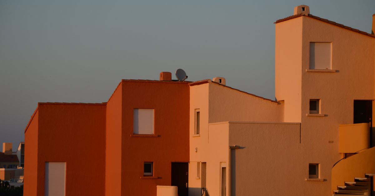 Minimalist residential building facade with evening sunlight casting warm tones on the structure.