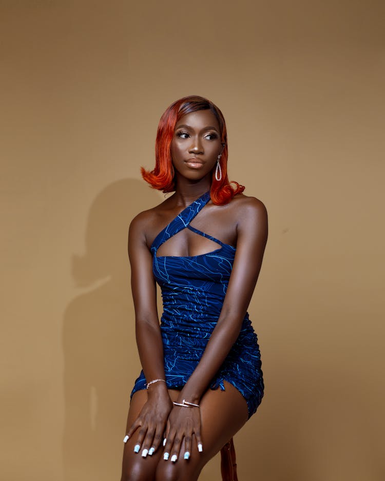 Beautiful Woman Sitting On Stool In Studio