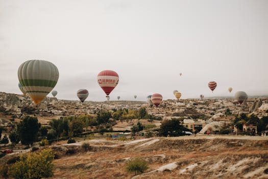 Colorful hot air balloons soar over the unique rock formations of Cappadocia, Turkey.