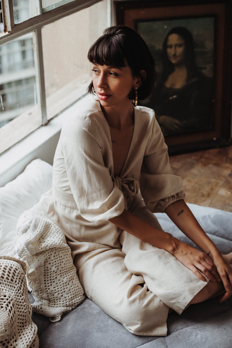 Woman Sitting On Sofa Looking In Window