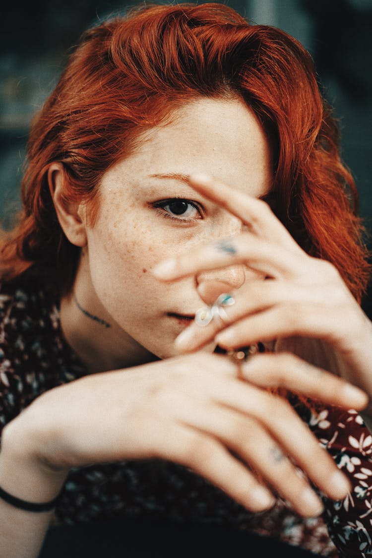 Redhead Woman Looking From Between Fingers