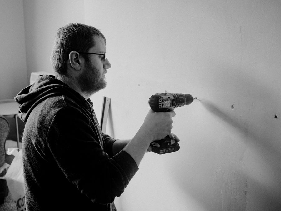 Handyman drilling into an interior wall