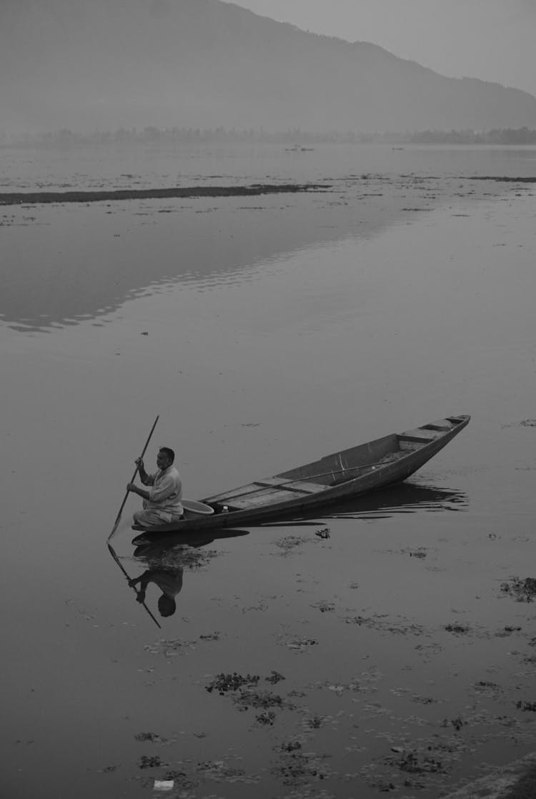 Monochrome Photo Of A Person Riding A Boat In A River 