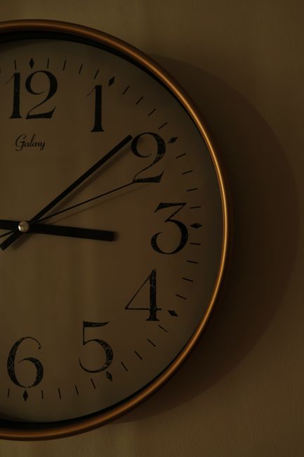 A vintage wall clock showing time with elegant hands and numbers, captured in soft lighting.