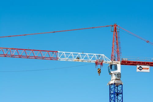 Red and White Crane Tower Under Blue Sky