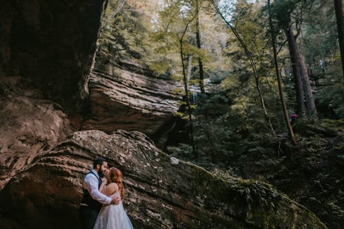 Wedded Couple Kissing Under Cliff