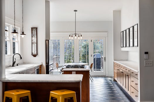 Sleek modern kitchen with natural light, white walls, and wooden cabinets for contemporary interior design.