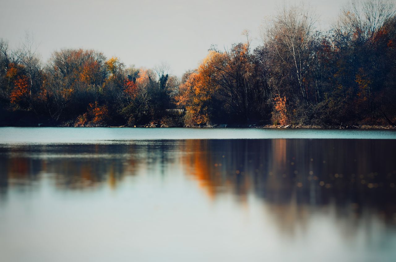 peaceful autumn scene with colorful trees reflecting in a calm river