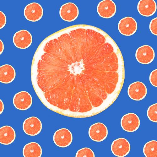 Free Vibrant grapefruit slices arranged against a vivid blue background. Perfect for fresh and modern concepts. Stock Photo