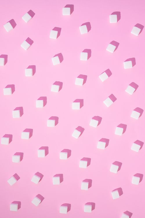 Free Sugar cubes arranged on a pastel pink background creating a sweet pattern. Stock Photo