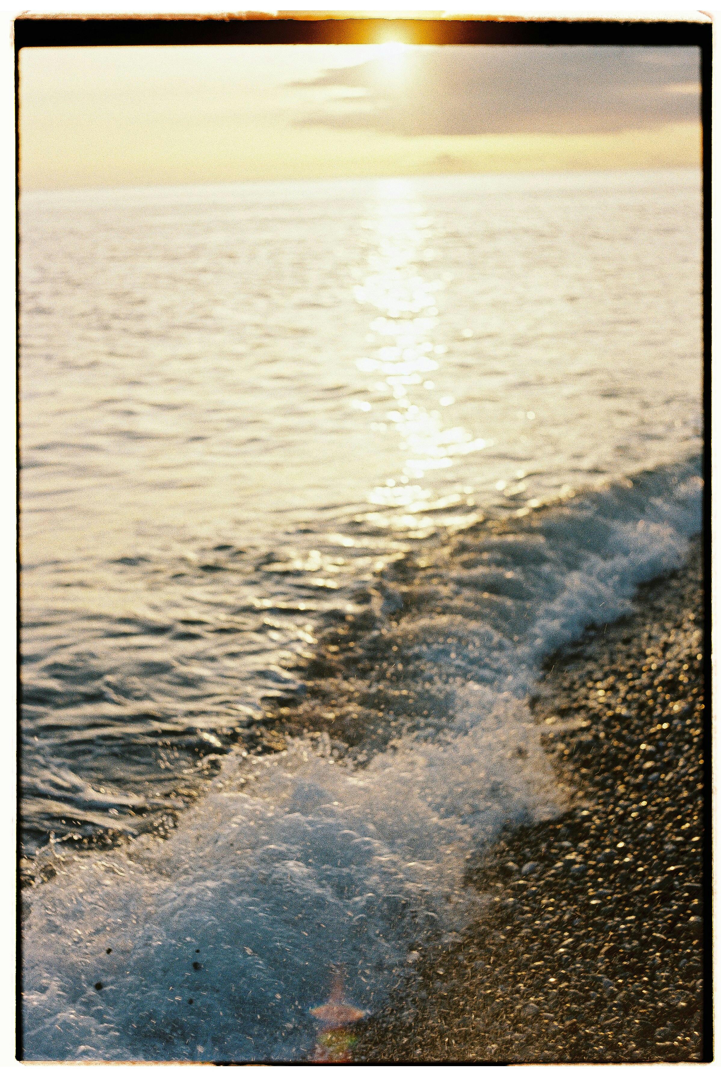 Captivating close-up of ocean waves splashing on a beach during sunset.