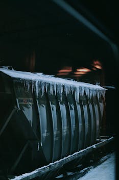 A freight train car adorned with icicles captured in a cold winter setting, highlighting the harsh weather conditions.