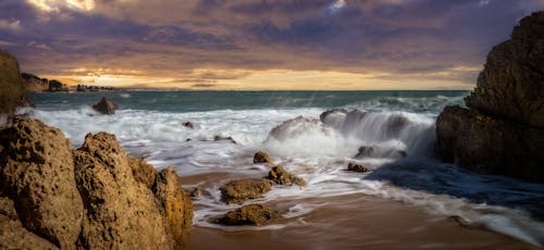 Waves Splashing on Rocks on Beach on Dusk