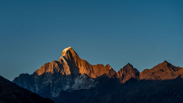 Stunning view of mountain peaks illuminated by sunset, showcasing natural beauty.