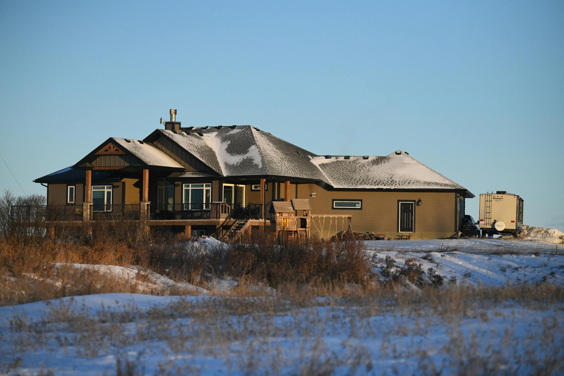 Winter morning in rural Edmonton showing a snow-covered house and caravan.