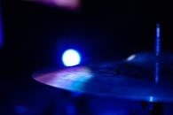 戏剧性的特写镜头中，鼓钹在蓝色照明下从黑暗背景中突出