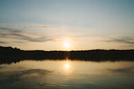 宁静的日落下，平静的海水倒映着充满活力的天空