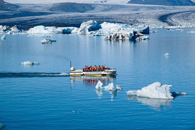 People On Boat In Expedition In Water With Glaciers