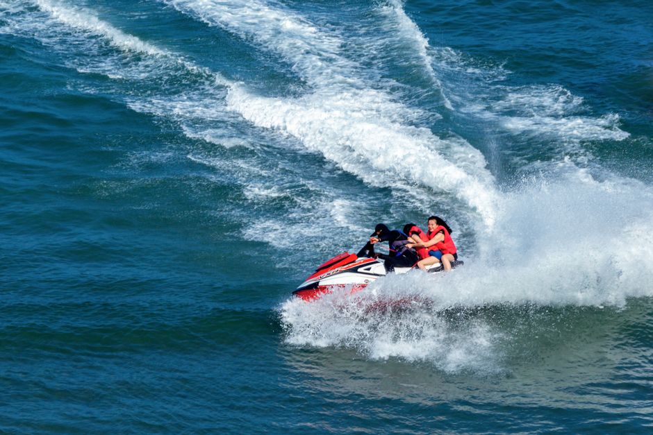 海でのスリリングなジェットスキーライドを楽しむグループ、飛び散る水しぶきと波を作り出しています。