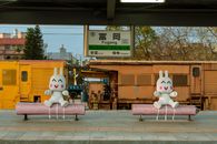 Two whimsical bunny figures are sitting on benches at Fugang railway station, adding a fun touch.
