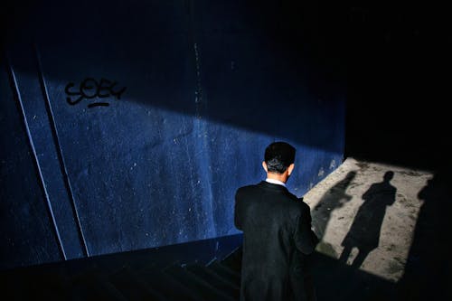 Man in a Coat Going Down the Stairs into a Tunnel in City 